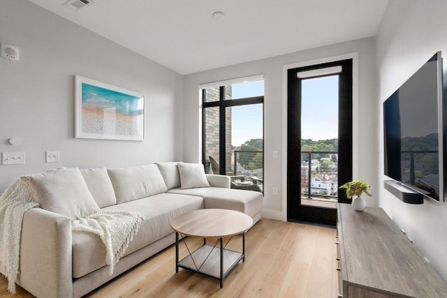 living area featuring light wood-type flooring and visible vents