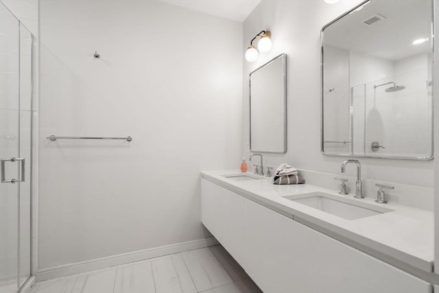 bathroom featuring visible vents, a sink, a shower stall, and baseboards