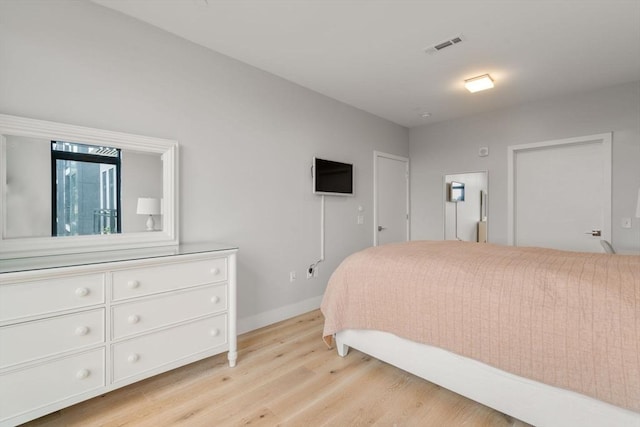 bedroom featuring light wood-type flooring, baseboards, and visible vents