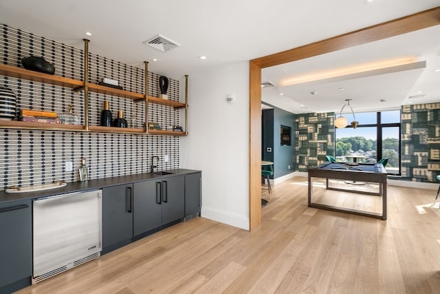 bar featuring light hardwood / wood-style flooring, sink, stainless steel refrigerator, and pool table