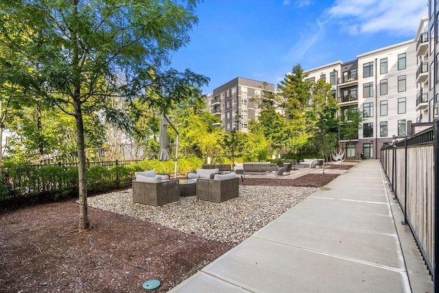 view of property's community with fence and outdoor lounge area