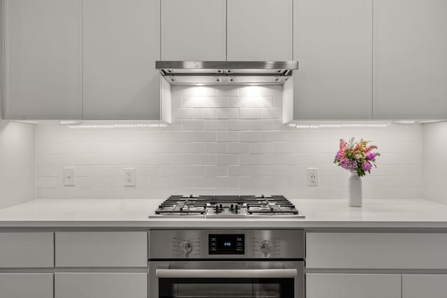 kitchen featuring backsplash, appliances with stainless steel finishes, and white cabinetry