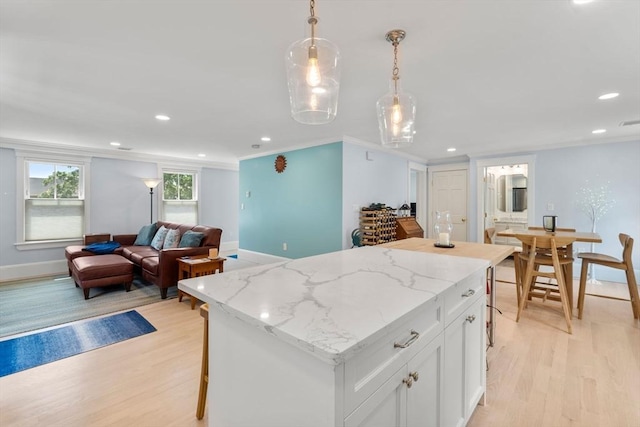 23 Union St Unit 2, Salem, MA 01970 - kitchen featuring light wood-style flooring, a center island, white cabinets, open floor plan, and ornamental molding