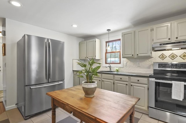 kitchen featuring light tile patterned floors, stainless steel appliances, dark countertops, decorative backsplash, and under cabinet range hood