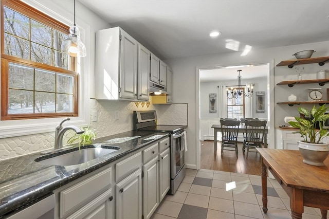 kitchen with stainless steel appliances, hanging light fixtures, a sink, and under cabinet range hood