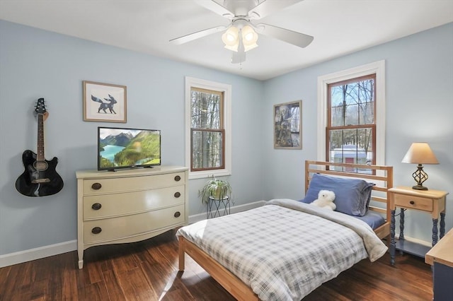 bedroom featuring multiple windows, dark wood finished floors, a ceiling fan, and baseboards