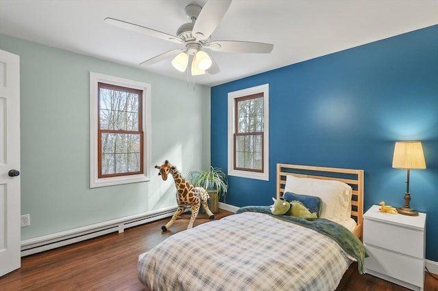 bedroom featuring a baseboard heating unit, dark wood finished floors, and a ceiling fan