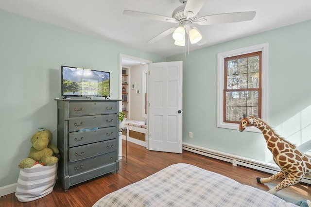 bedroom with a baseboard radiator, baseboards, dark wood finished floors, and a ceiling fan