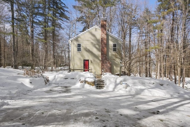 view of snow covered exterior featuring a chimney