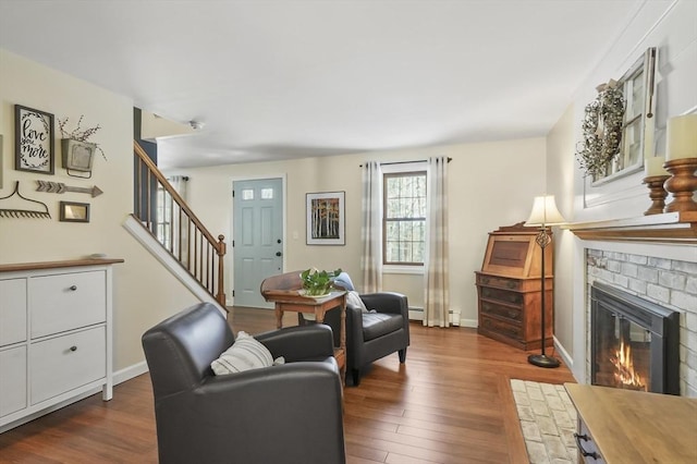 interior space featuring dark wood-style floors, a fireplace, stairs, and baseboards