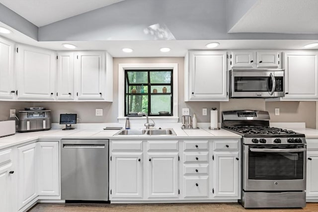17 High St, Merrimac, MA 01860 - kitchen featuring stainless steel appliances, a sink, lofted ceiling, white cabinets, and recessed lighting
