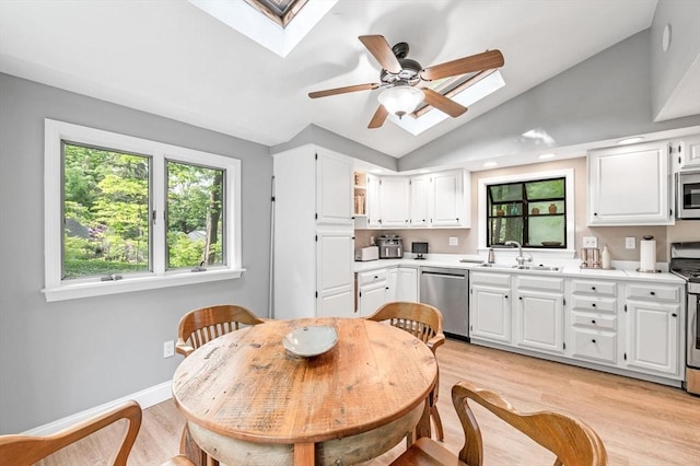 17 High St, Merrimac, MA 01860 - kitchen with appliances with stainless steel finishes, a skylight, a sink, light wood-style flooring, and lofted ceiling