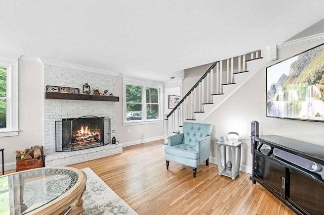 17 High St, Merrimac, MA 01860 - living room featuring light wood-style floors, a brick fireplace, crown molding, baseboards, and stairway