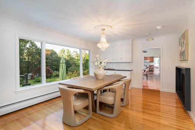 dining room with crown molding, baseboard heating, an inviting chandelier, and light hardwood / wood-style flooring