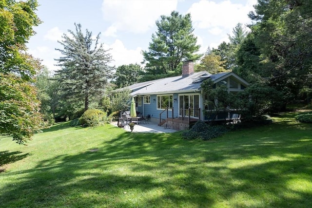 rear view of property with a patio area and a lawn