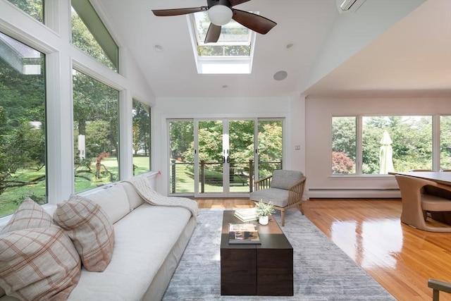 sunroom featuring ceiling fan, a baseboard heating unit, and vaulted ceiling with skylight