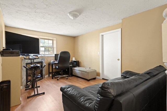 office space featuring a textured ceiling, wood finished floors, and radiator