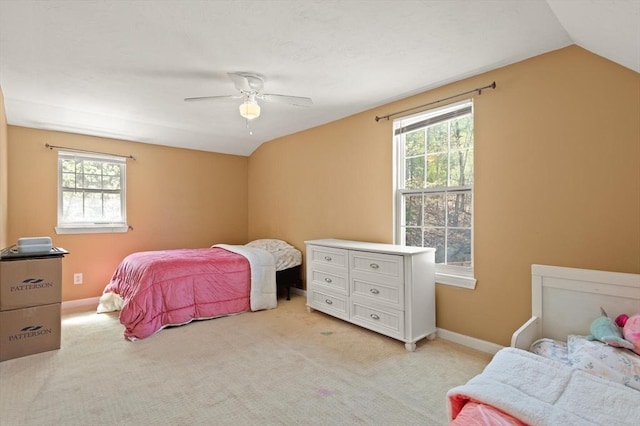 bedroom with baseboards, multiple windows, light carpet, and vaulted ceiling