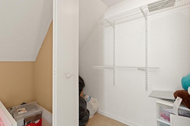 walk in closet featuring lofted ceiling