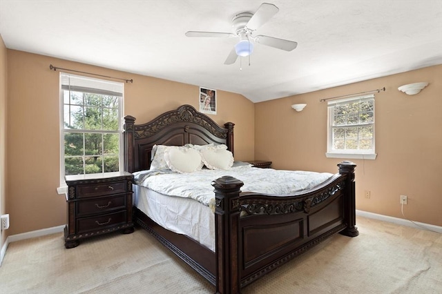 bedroom with a ceiling fan, baseboards, vaulted ceiling, and light carpet