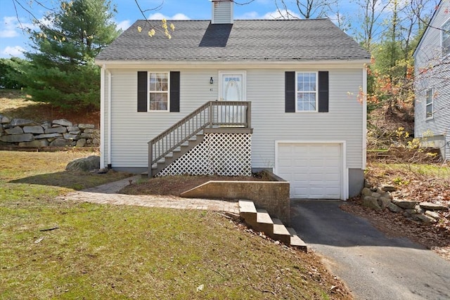 view of front of house featuring a shingled roof, a front lawn, a garage, a chimney, and driveway