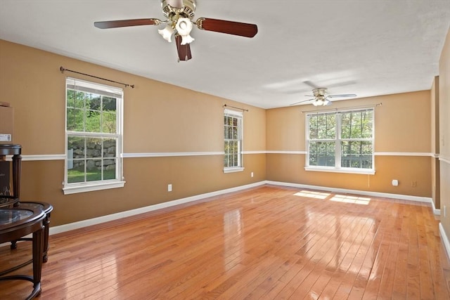 empty room featuring baseboards, ceiling fan, and hardwood / wood-style floors