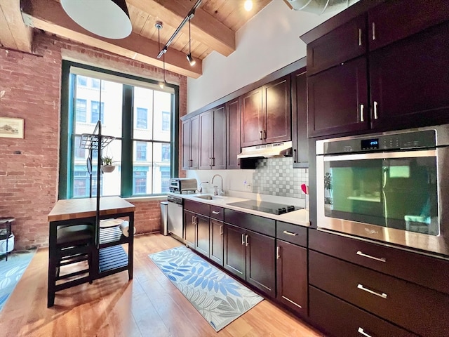 kitchen with beamed ceiling, light hardwood / wood-style flooring, wood ceiling, brick wall, and appliances with stainless steel finishes