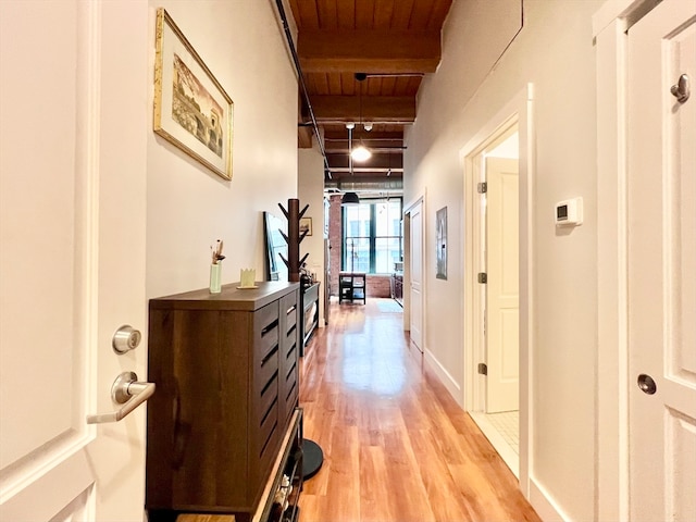 corridor featuring beamed ceiling, wood ceiling, and light hardwood / wood-style flooring