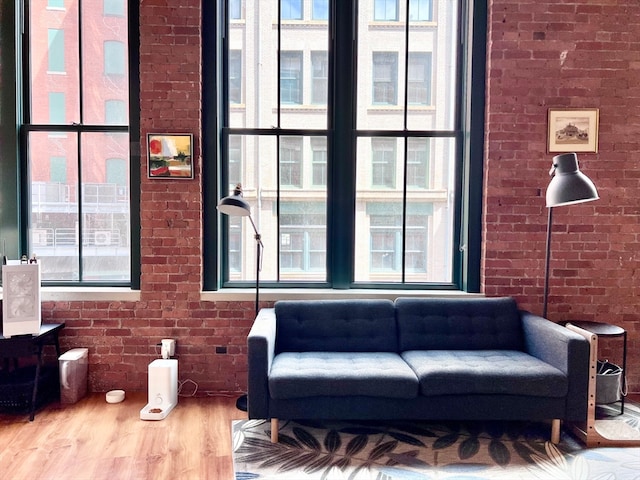 interior space with brick wall and hardwood / wood-style floors