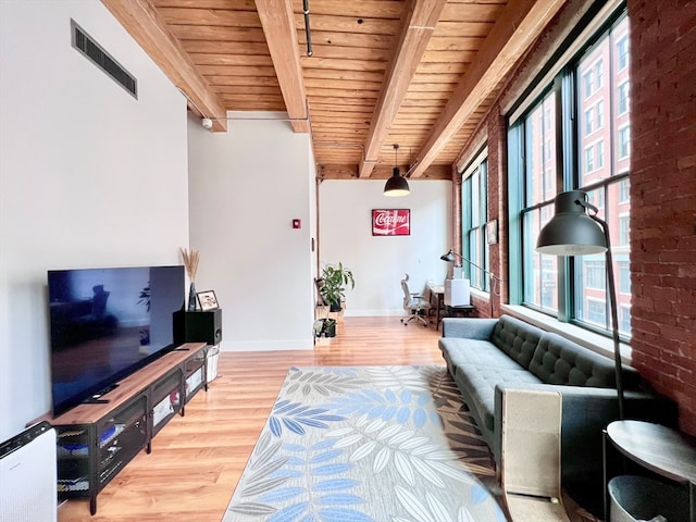 living room featuring beamed ceiling, wood ceiling, plenty of natural light, and hardwood / wood-style floors