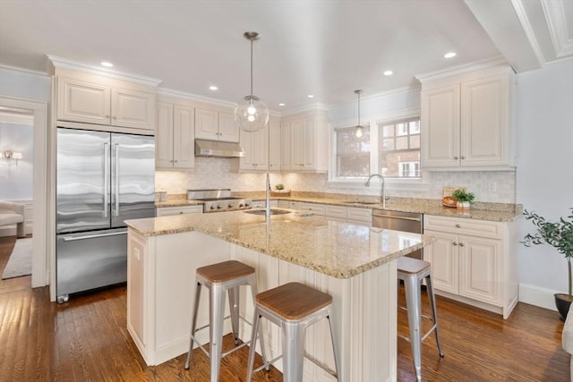 kitchen with pendant lighting, sink, a center island, and appliances with stainless steel finishes