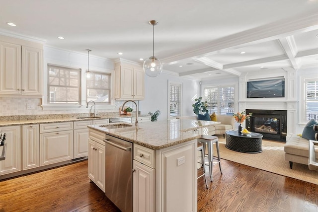 kitchen with sink, decorative light fixtures, a center island with sink, dishwasher, and beam ceiling