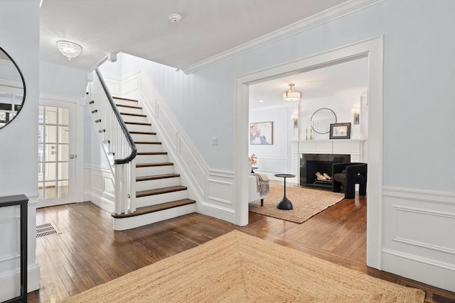 stairway featuring crown molding and hardwood / wood-style flooring