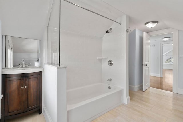 bathroom featuring tiled shower / bath combo, vanity, lofted ceiling, and hardwood / wood-style flooring