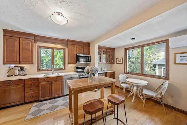41 Dale Ave, Quincy, MA 02169 - kitchen featuring stainless steel appliances, light wood-type flooring, brown cabinets, light countertops, and a textured ceiling