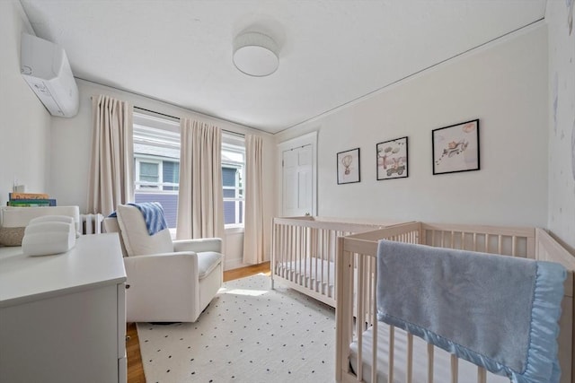 41 Dale Ave, Quincy, MA 02169 - bedroom with a wall mounted air conditioner, light wood-type flooring, and a crib