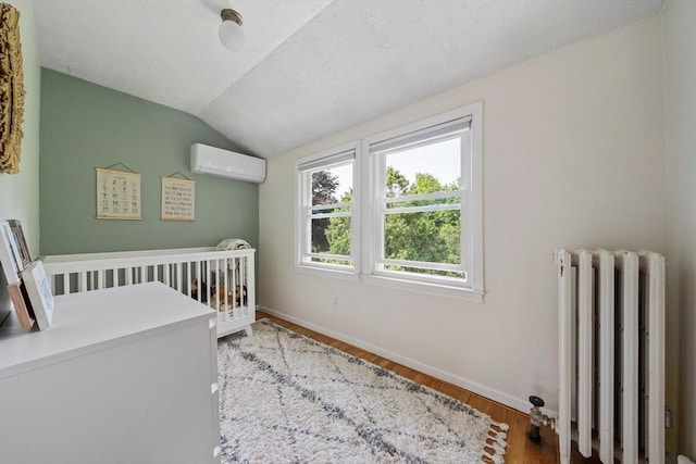 41 Dale Ave, Quincy, MA 02169 - bedroom featuring radiator heating unit, a wall mounted AC, vaulted ceiling, wood finished floors, and a nursery area