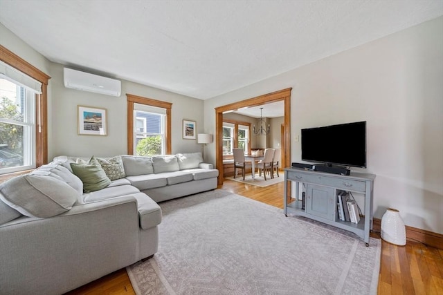 41 Dale Ave, Quincy, MA 02169 - living room featuring a wall mounted AC, wood finished floors, and a chandelier