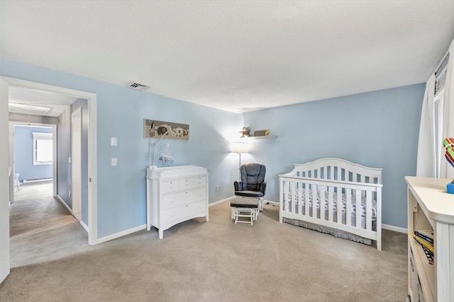 bedroom featuring light carpet, a baseboard radiator, and a crib