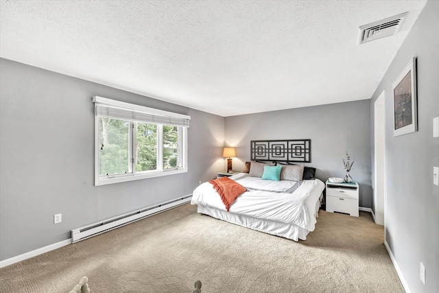 carpeted bedroom featuring a baseboard heating unit and a textured ceiling