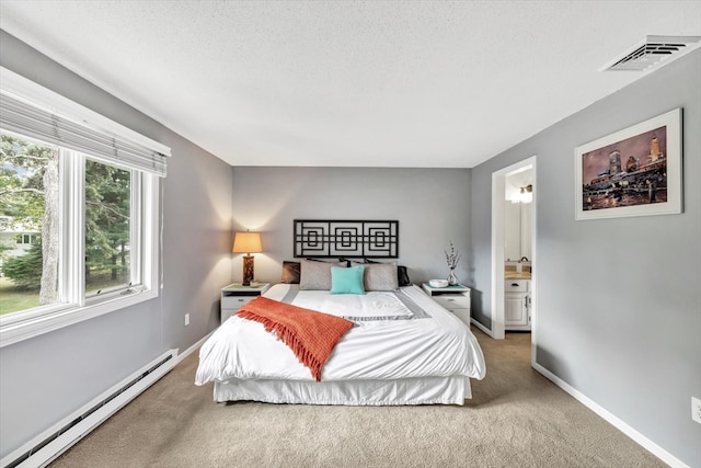 bedroom featuring carpet floors, a textured ceiling, ensuite bath, and a baseboard heating unit