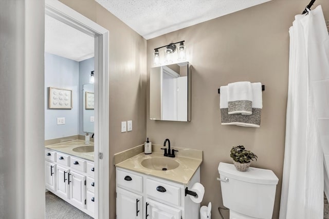 bathroom featuring a textured ceiling, vanity, and toilet