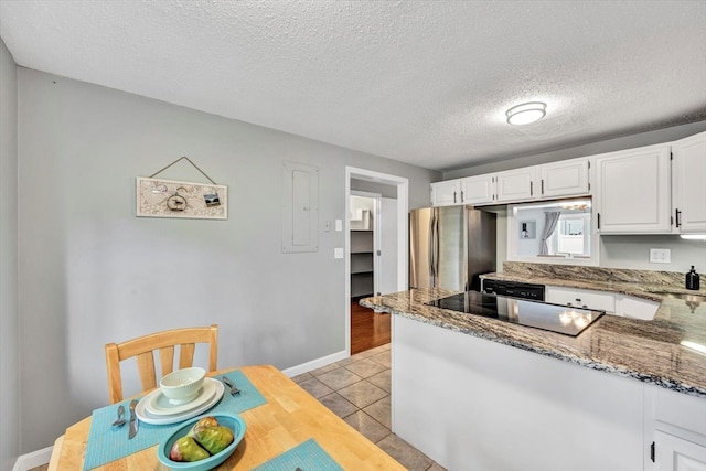 kitchen with stainless steel fridge, light tile patterned flooring, white cabinetry, stone countertops, and a textured ceiling