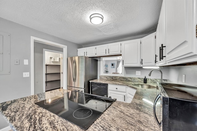 kitchen featuring white cabinetry, a textured ceiling, black appliances, dark stone counters, and sink