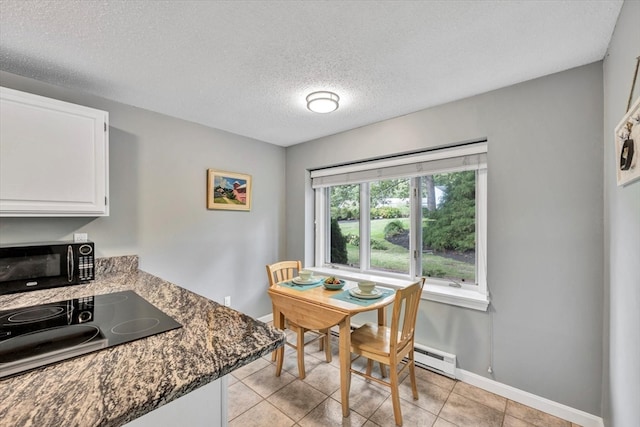 dining area featuring a textured ceiling and light tile patterned floors