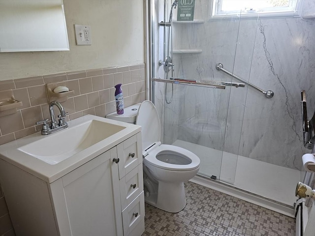 full bathroom with toilet, tile walls, a marble finish shower, and vanity
