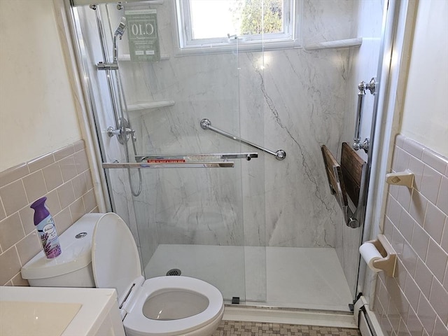 full bath featuring tile walls, a wainscoted wall, toilet, and a marble finish shower