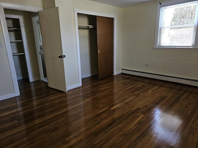 unfurnished bedroom with baseboards, a baseboard radiator, a closet, and dark wood finished floors
