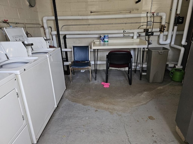 washroom featuring concrete block wall and washing machine and dryer
