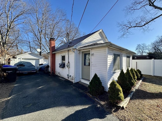 view of front of house featuring a garage and an outbuilding